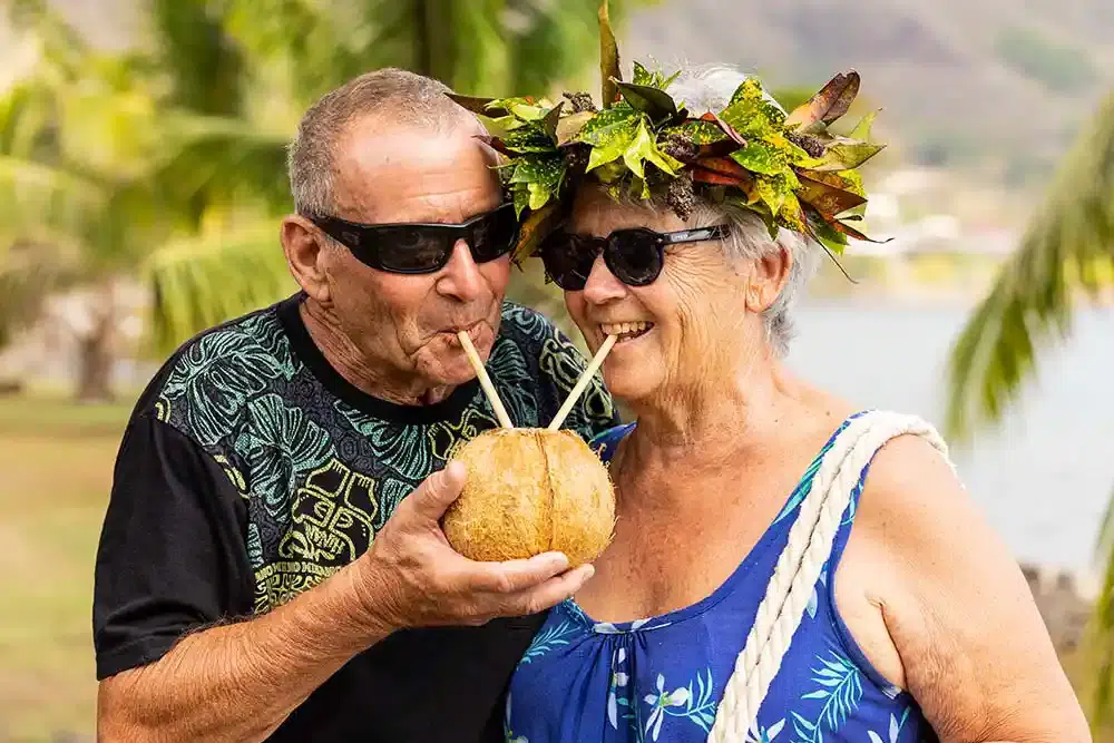 Senior couple enjoying a coconut drink in Tahiti
