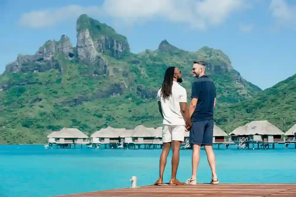 Couple holding hands at Bora Bora mountains for LGBT+ paradise